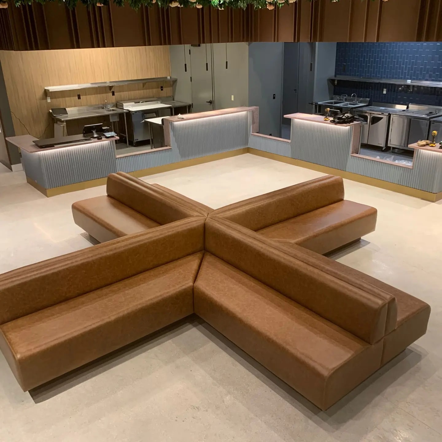 Custom four-way cognac leather banquette built in a cross shape by Andinos Custom Designs, installed in a South Florida dining hall