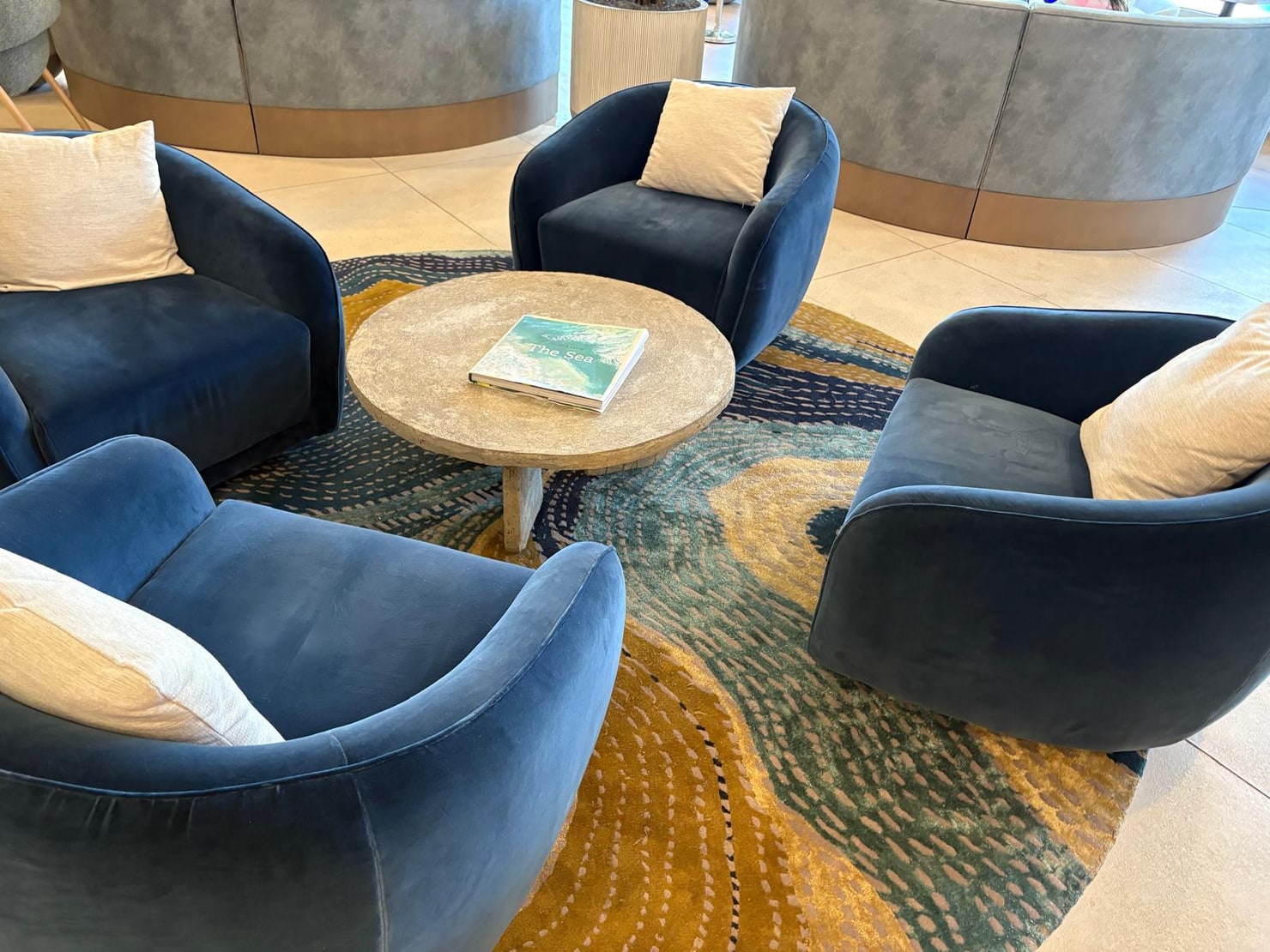 Four custom navy velvet swivel chairs around a stone table