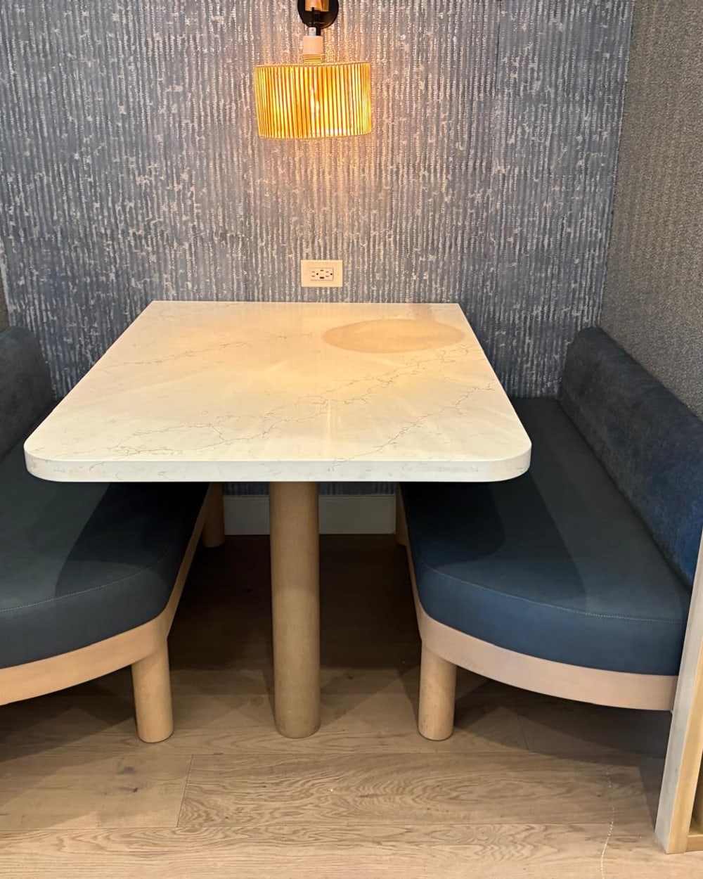 Custom teal leather booth seating with a stone top and light oak frame